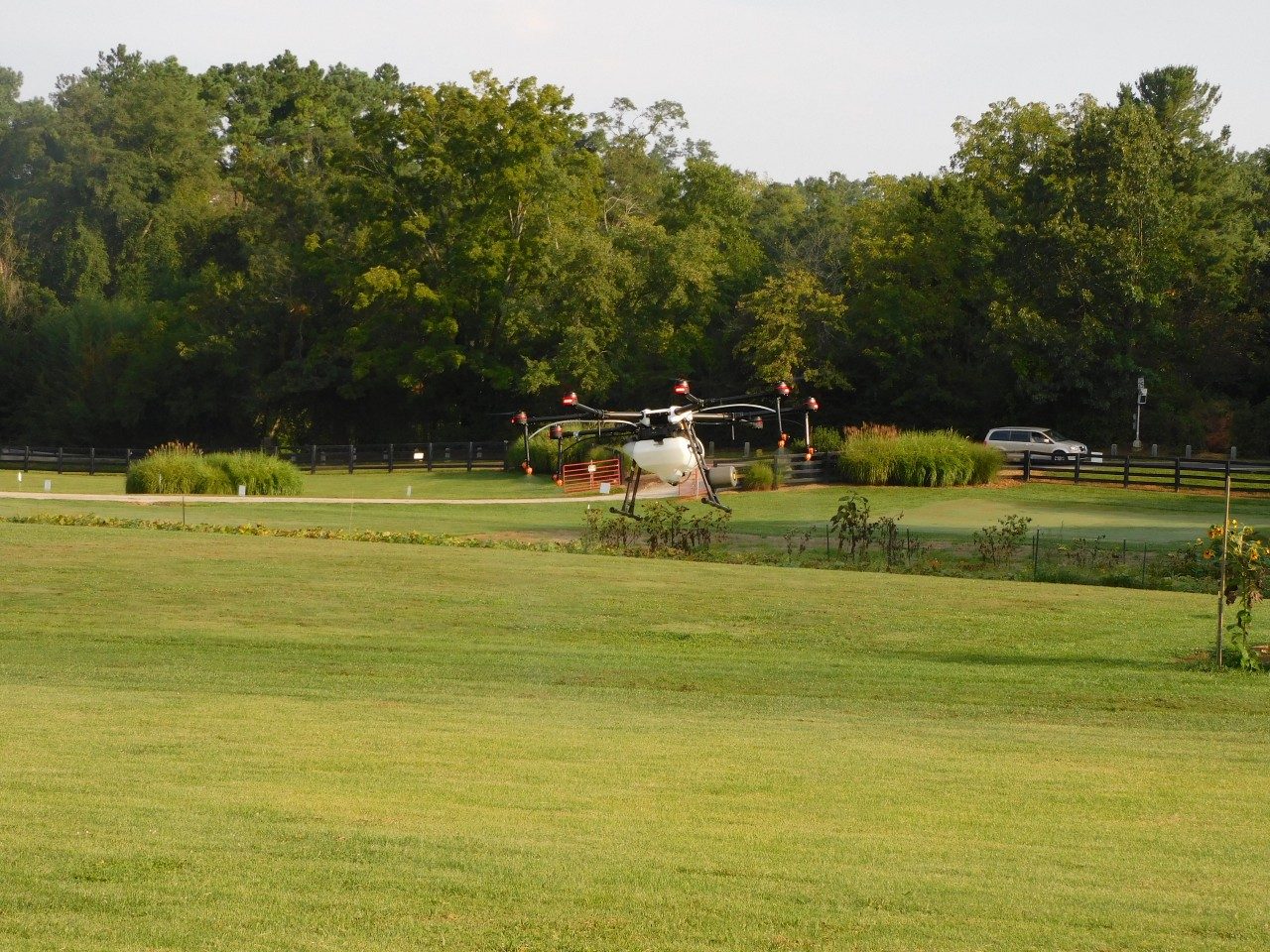 A drone hovers above the ground at the Turfgrass Research Center.