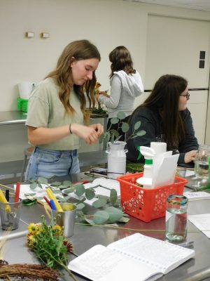 Students design flower arrangements during a free design lab.
