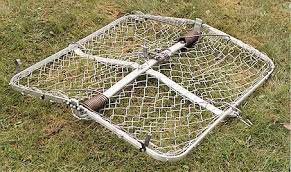 An open, square-shaped trap with a metal frame around chain-link wire hinged with springs in the center.